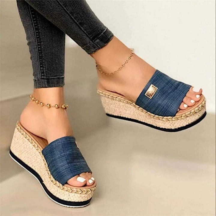 Front view, Kaya Summer Platform Sandals with denim blue straps and woven wedge heels, worn with dark jeans