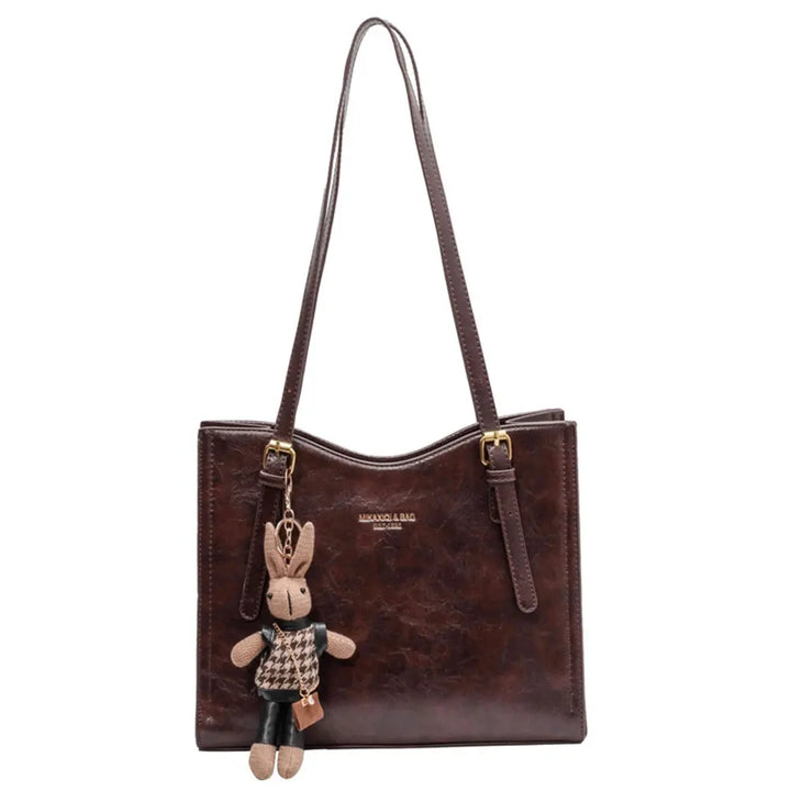 Front view of the brown vegan leather Gwen bag with a cute rabbit charm on a white background