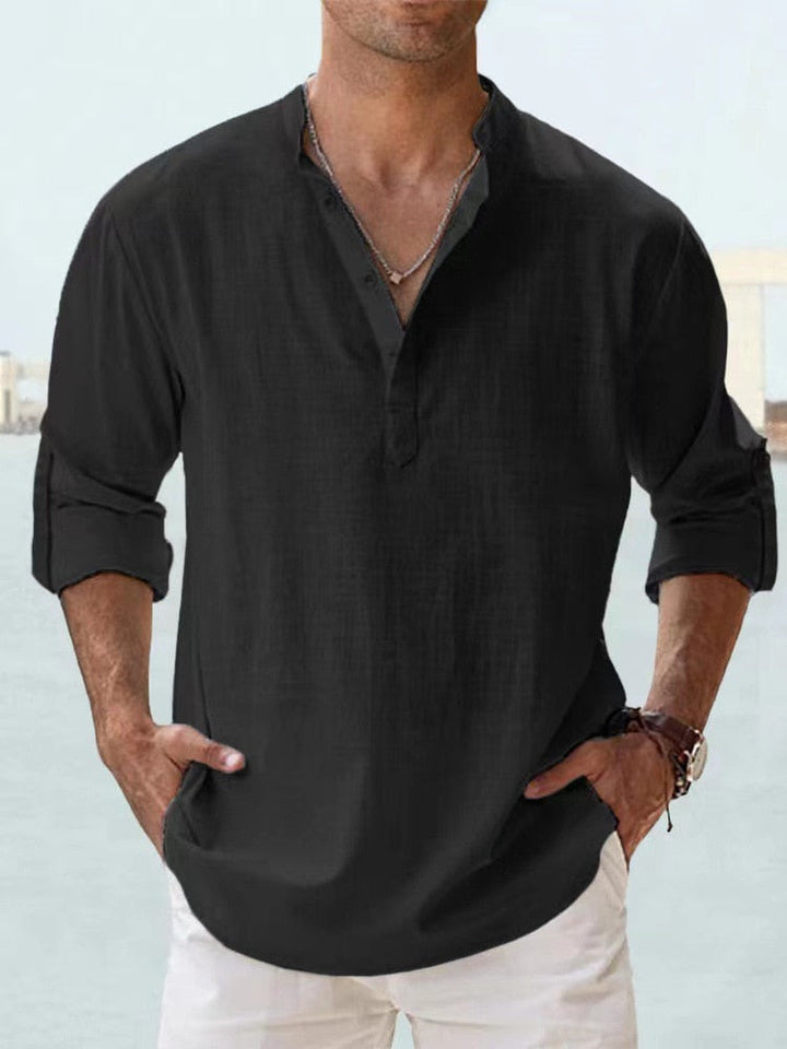Front view of a man wearing a black breathable cotton shirt with a Henley collar and rolled up sleeves