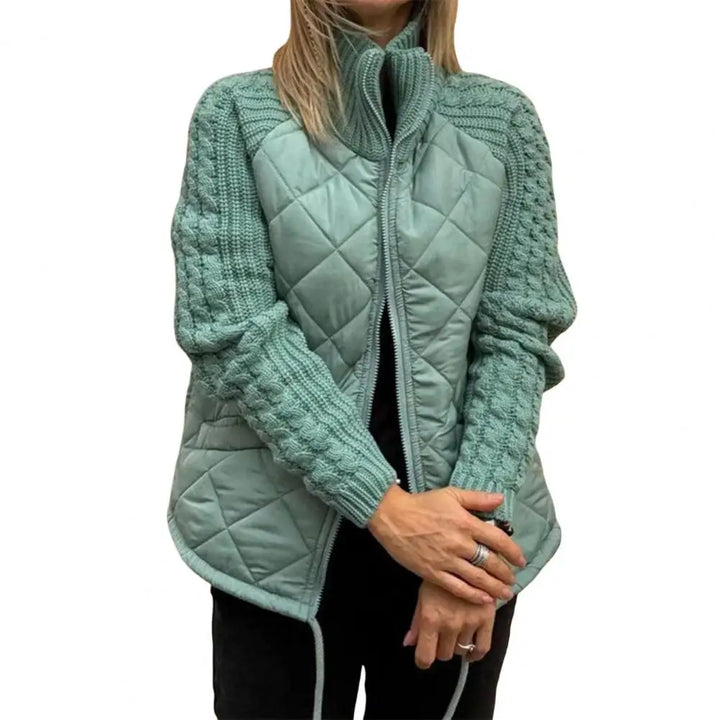 Front view worn by model, a woman in a sage green quilted knit jacket with an open zip and high collar