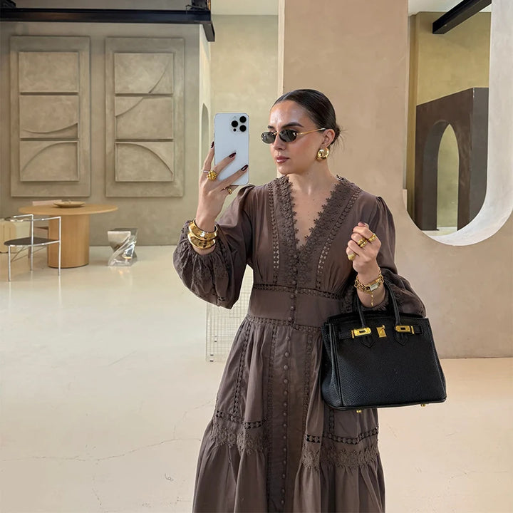Worn by model, a brown elegant lace patchwork dress with puff sleeves, holding a phone and a black handbag