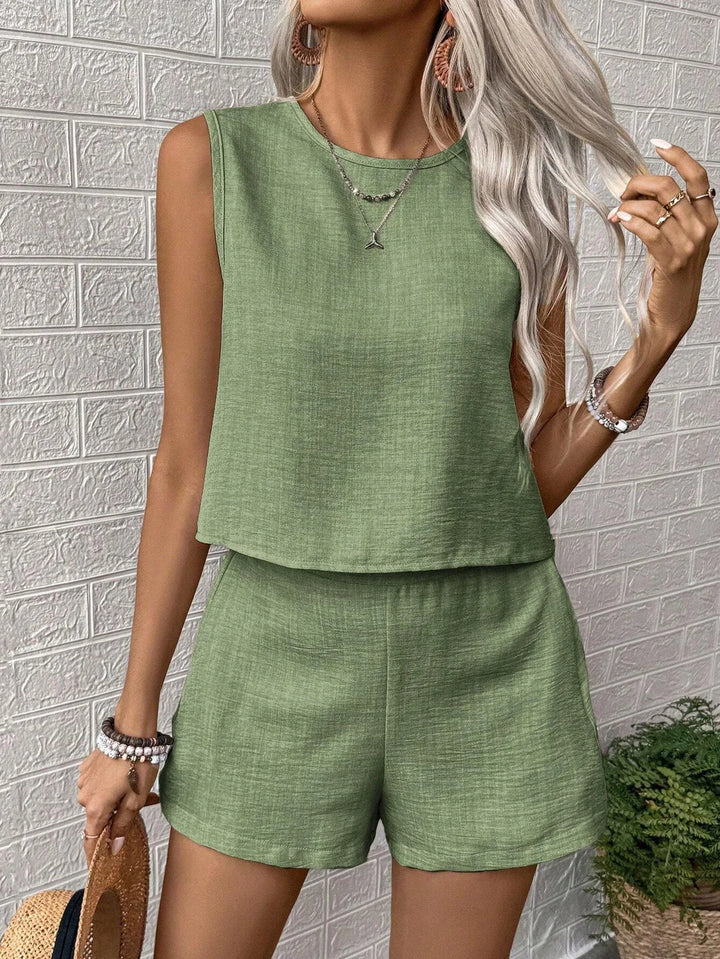 Front view, model wearing the sage green Ivy Crop Top and Shorts Set, with a layered necklace and earrings