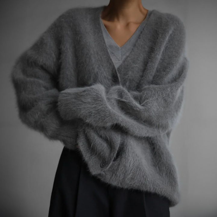 Close up of a model wearing a fluffy grey oversized V-neck knit cardigan with rolled up sleeves