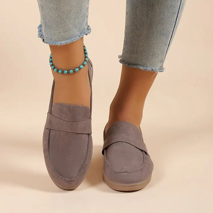 Front view worn by model, grey suede loafers with brown soles, light blue jeans, and a turquoise anklet
