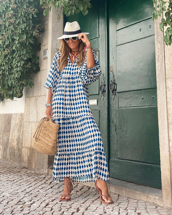 Bohemian Floral Maxi Dress worn by model, front view, with a blue and white diamond pattern and straw bag