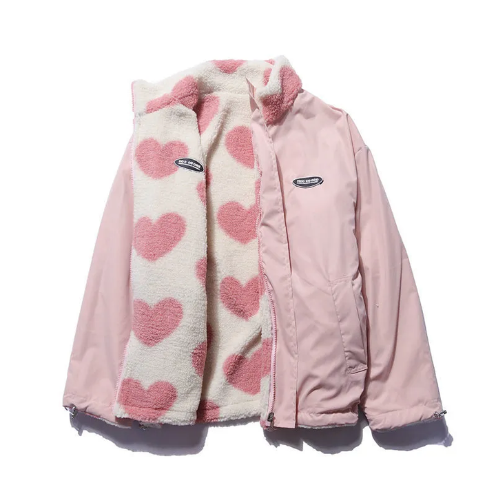 Flat lay of a pink double-sided lambswool jacket with a heart print lining, zipper partly open