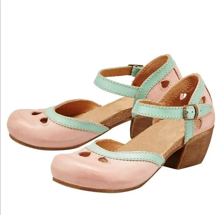 Side view of a pair of pink retro colour-block sandals with mint green buckle straps, cut-outs and a brown mid-heel
