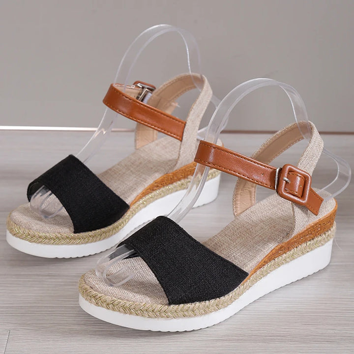 Back view of Vera Retro Wedge Sandals on clear stands, showing black toe straps and brown ankle straps with buckles