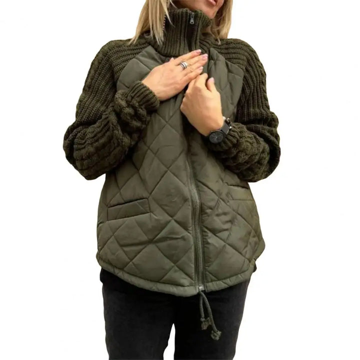 Front view worn by model, a woman wearing a sage green quilted knit jacket with hands on the chest
