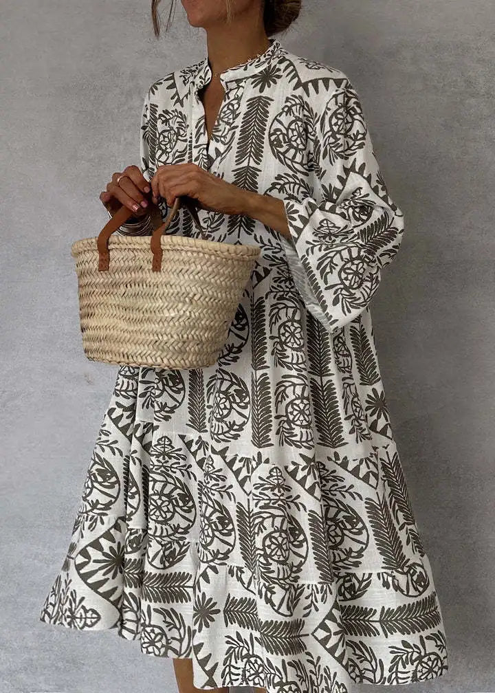 Printed V-Neck A-Line Skirt Dress worn by model, close up, holding a small woven bag