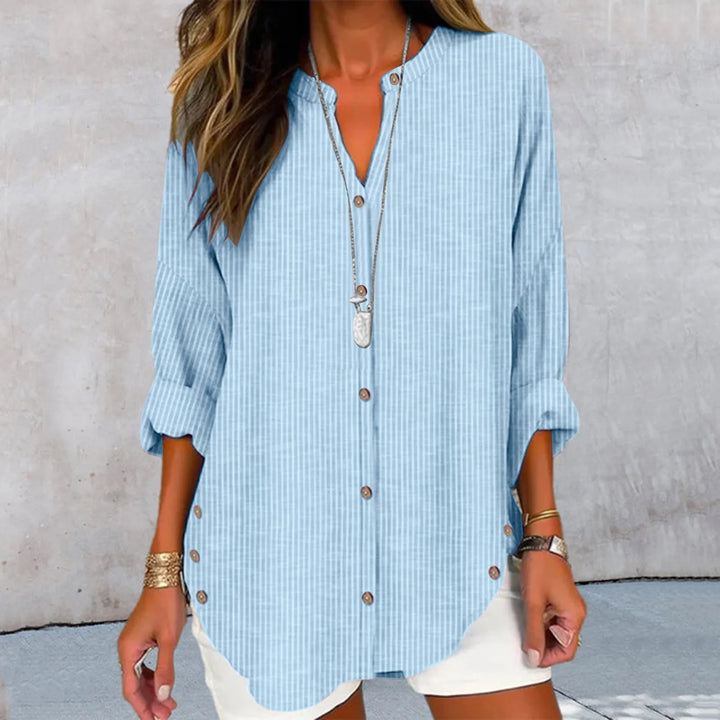 Front view of the Kaia printed button blouse in light blue and white stripes with a long necklace
