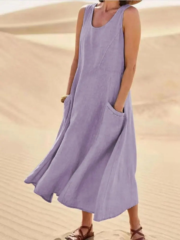 Front view of Anna A-Line Sleeveless Midi Dress in purple with pockets, worn by model on sand dunes