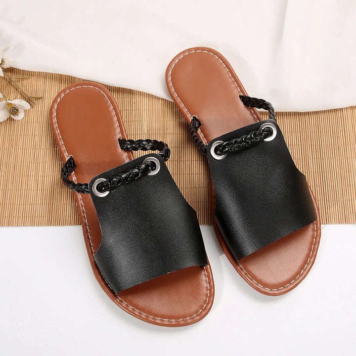 Top view of a pair of black Maya Square-Toe Flat Sandals with braided back straps and silver eyelets
