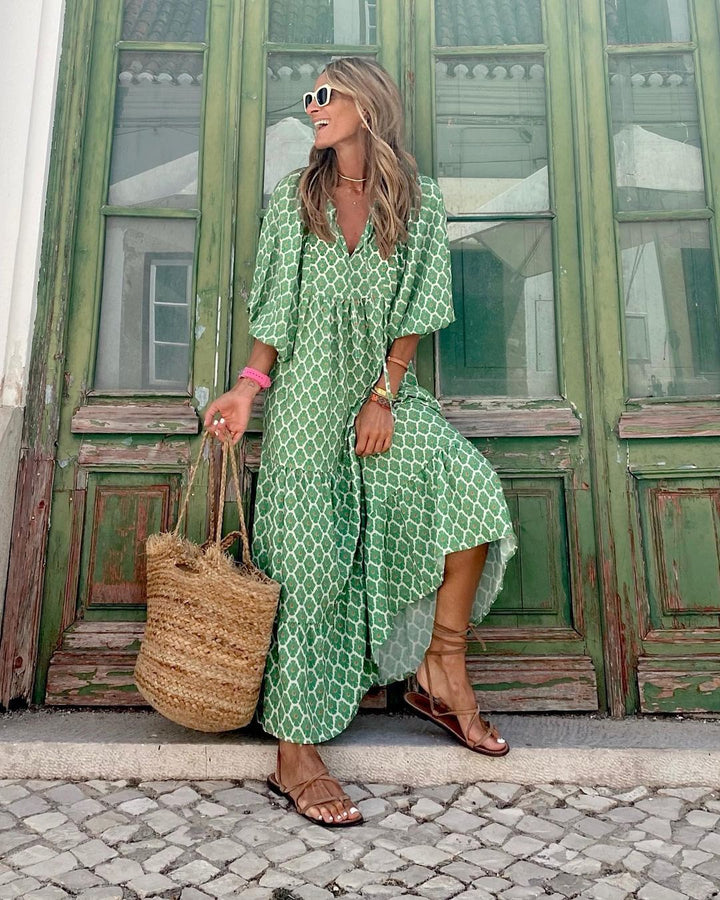 Bohemian Floral Maxi Dress worn by model, three quarter view, with a green and white geometric pattern and brown sandals