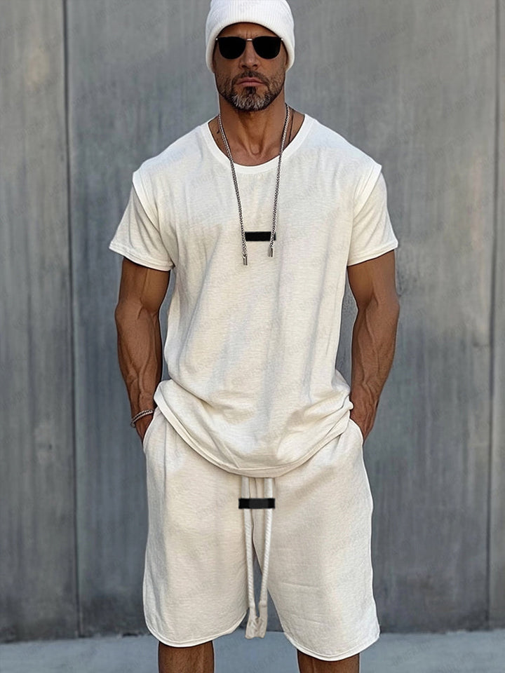 Front view of an Essential Sport Shorts and T-shirt set worn by a model against a grey wall