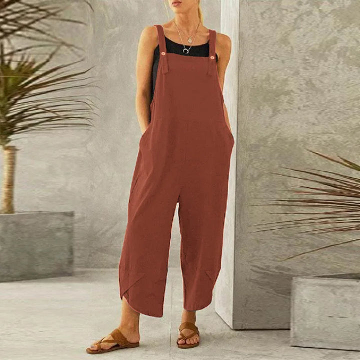 Front view of a model wearing the rust coloured Isla oversized cotton-linen summer overalls with a black top