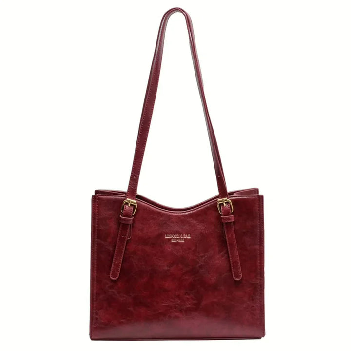 Front view of the red vegan leather Gwen bag with two buckle details and a subtle logo on a white background