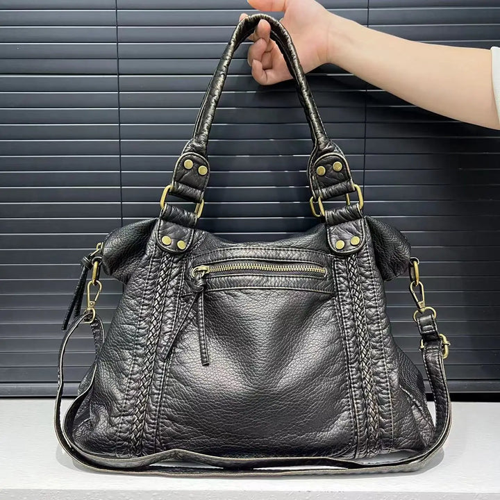 Worn by model, the Sienna vintage washed leather tote bag in black with a hand holding the top handle