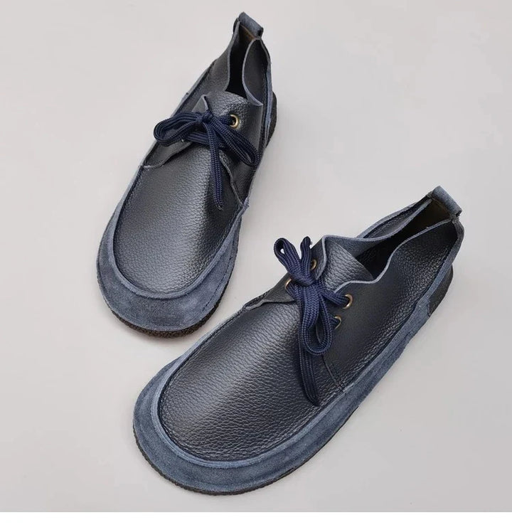 Top down view of a pair of Nora genuine leather flats in dark blue with blue laces and suede trim