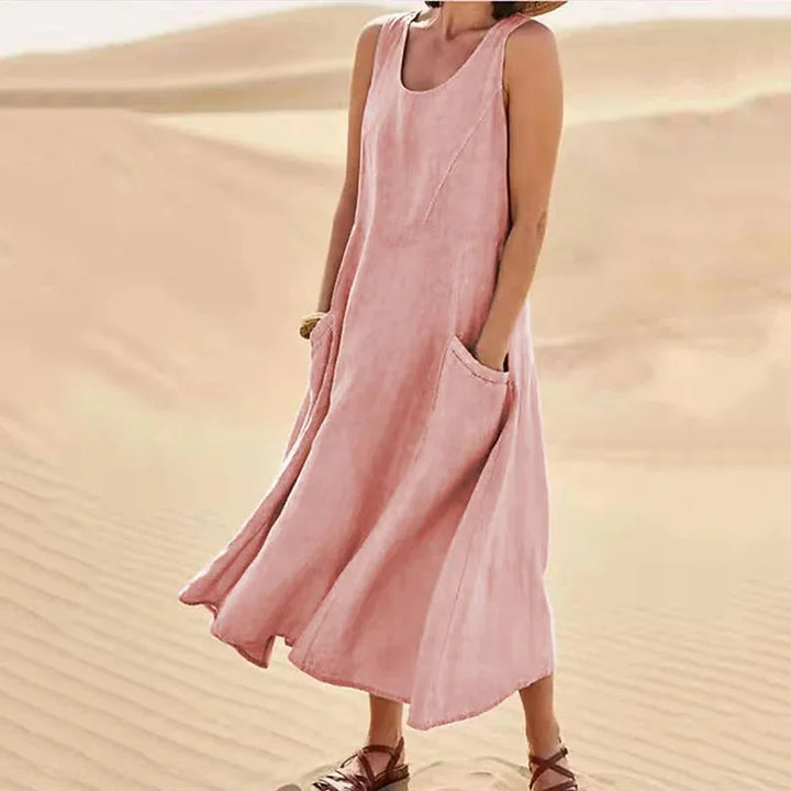 Front view of Anna A-Line Sleeveless Midi Dress in pink with pockets, worn by model on sand dunes