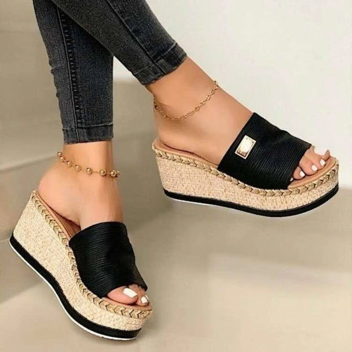 Worn by model, a pair of Kaya Summer Platform Sandals with black straps and woven wedge heels