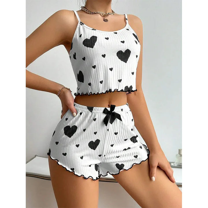 Front view of a model wearing a white pyjama set with black hearts, showing the soft sleepwear design