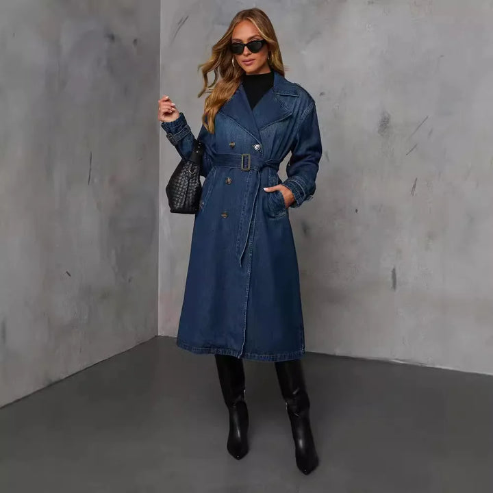 Xena long double-breasted denim trench coat worn by model, front view, with hand in pocket and black boots