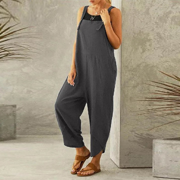 Three quarter view of a model wearing the dark grey Isla oversized cotton-linen summer overalls with a black top
