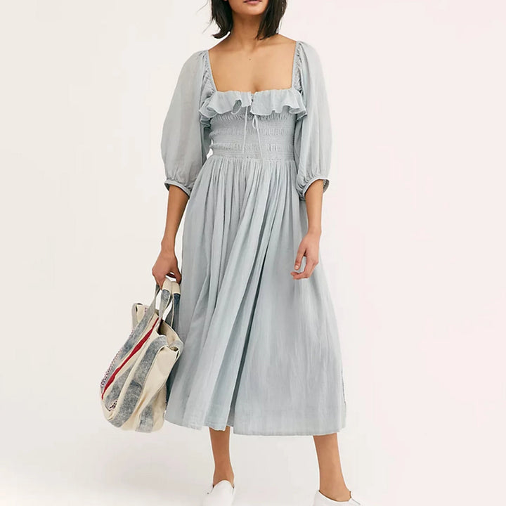 Fairycore square neckline mid-calf dress, front view worn by model, a woman in a light blue dress with a tote bag