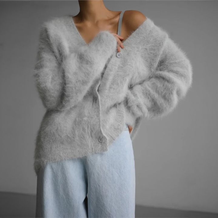 Front view of a model wearing a fluffy grey oversized V-neck knit cardigan with one shoulder exposed