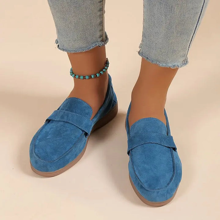 Front view worn by model, blue suede loafers with brown soles, light blue jeans, and a turquoise anklet