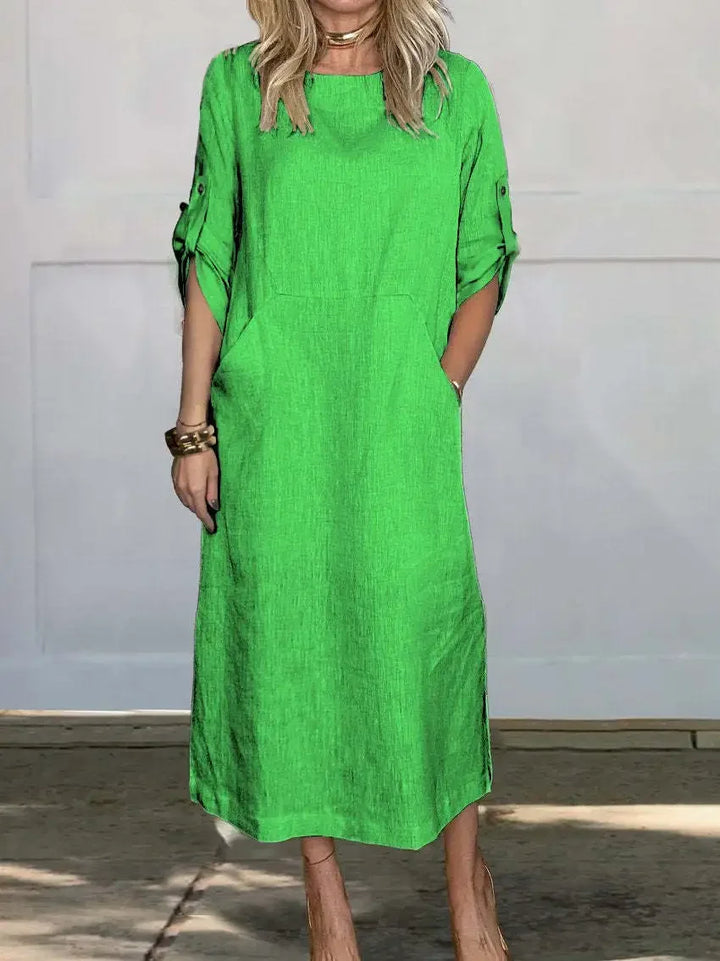 Front view of the Emma Linen Midi Dress in lime green, worn by a model with hands in side pockets