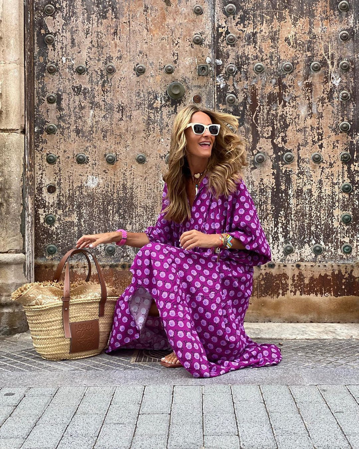 Bohemian Floral Maxi Dress worn by model, three quarter view, with a straw basket bag and white sunglasses