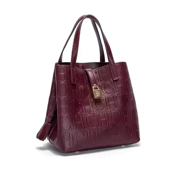 Three quarter view of a burgundy Kara Classic Large Bucket Handbag with embossed &