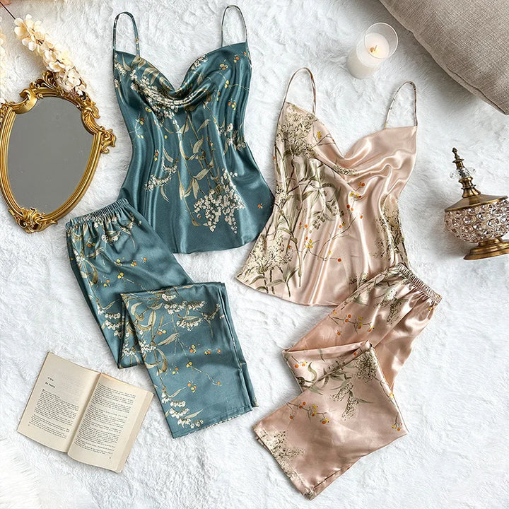 Flat lay of two elegant satin sleepwear sets, one teal and one blush, both with a delicate floral print