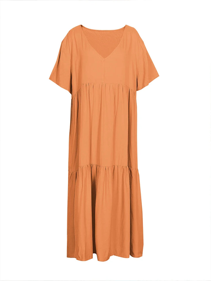 Flat lay of an orange plus size V-neck midi dress with pleated detail and short sleeves
