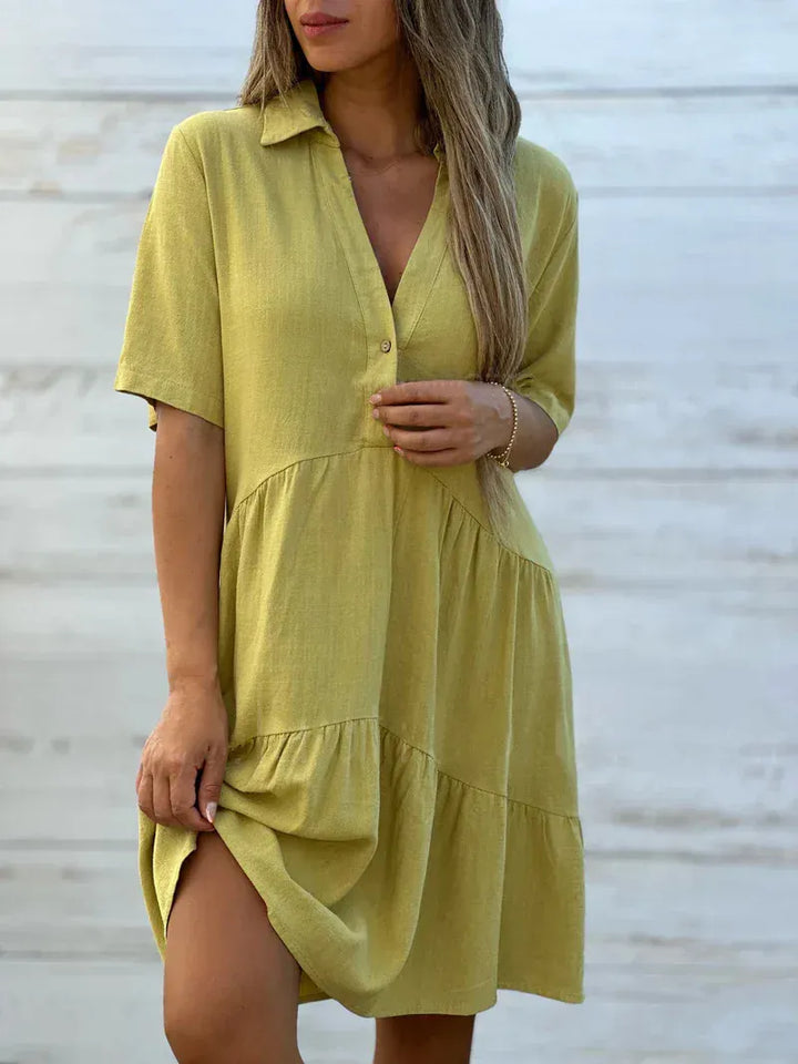 Front view of a model wearing a lime loose blouse mini dress with a collared V-neck and tiered skirt