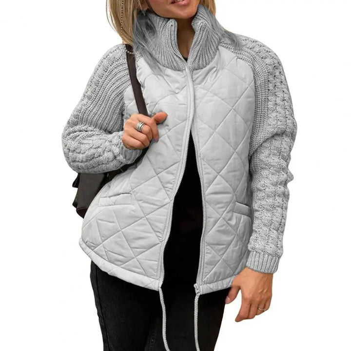 Front view worn by model, a woman wearing an open light grey quilted knit jacket with a high collar