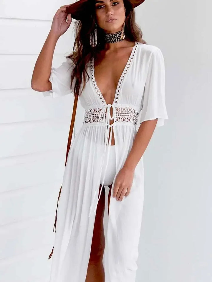 Front view of a model in a white bohemian lace beach cover-up with a wide crochet waist and a deep V-neck