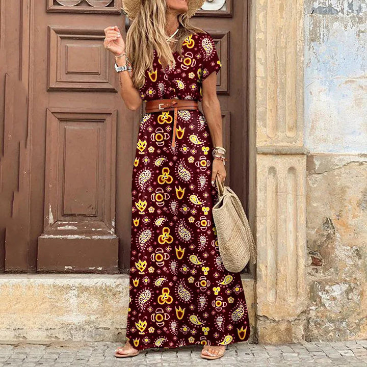 Side view of a model wearing the floral pleated midi dress with a straw hat and woven bag