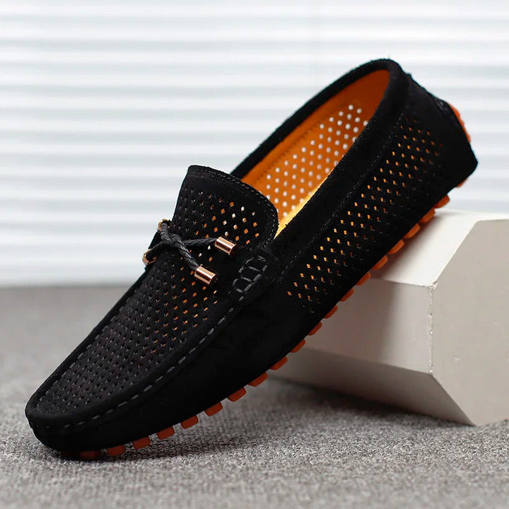 Front view of a black Austin slip-on loafer with perforated detail and orange sole accent
