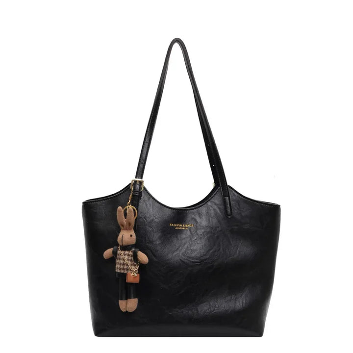 Front view of the Piper vegan leather tote bag in black with a cute bunny charm and subtle branding