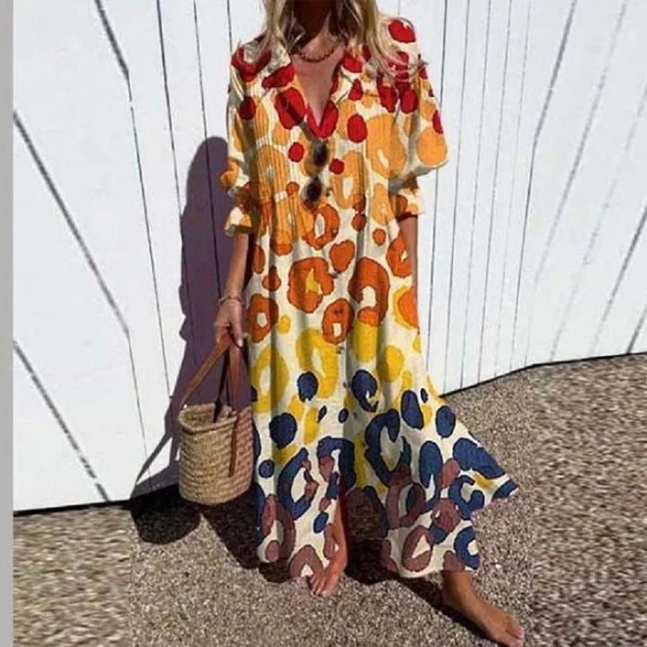Full length view of a model wearing the elegant pleated printed dress with a vibrant abstract pattern and a straw bag