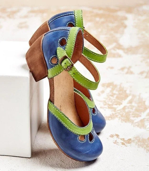 Close up three quarter view of blue retro colour-block sandals with green buckle straps and a brown mid-heel