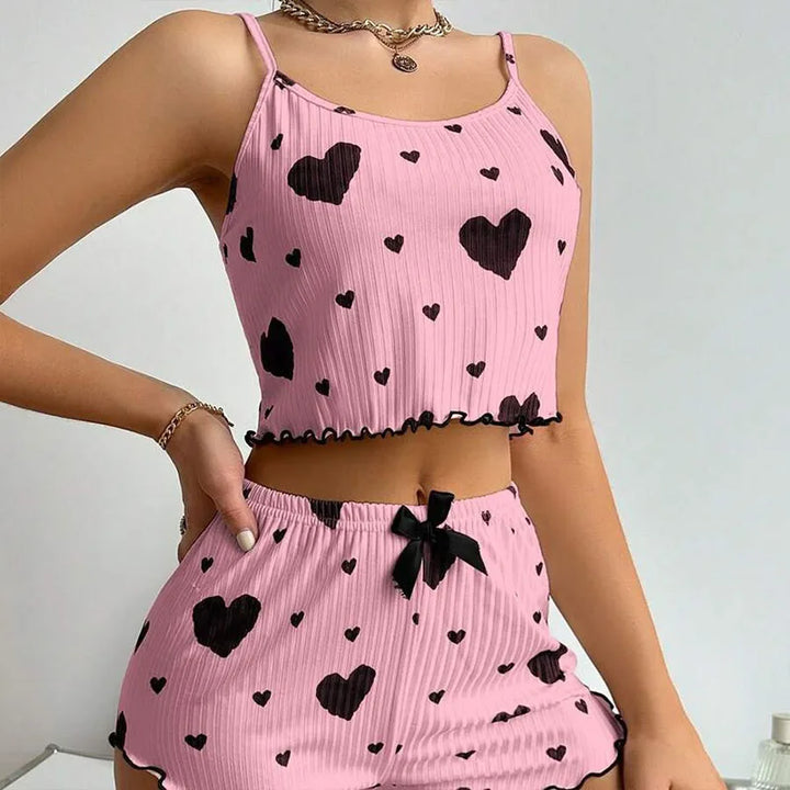 Side view of a model wearing a pink pyjama set with black hearts, showing the soft sleepwear