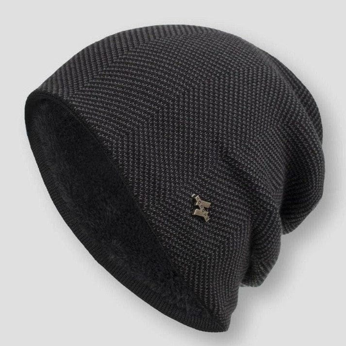 Three quarter view of the Classic Knitted Wool Beanie showing the dark grey chevron pattern and metallic logo badge