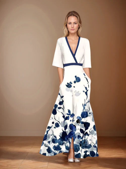 Front view, model wearing a white floral print wrap dress with a navy blue v neck and short sleeves, hands in pockets