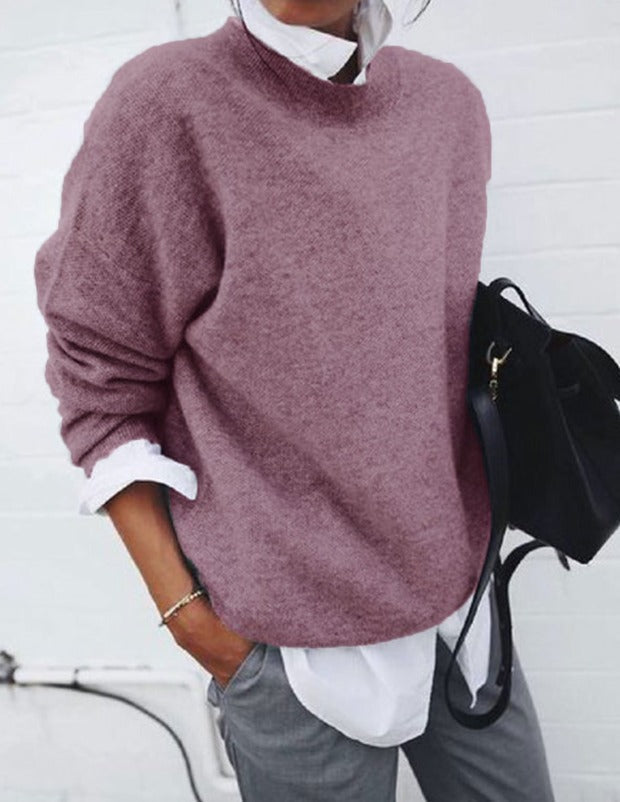Front view of a model wearing a mauve oversized knit jumper over a white shirt with grey pants