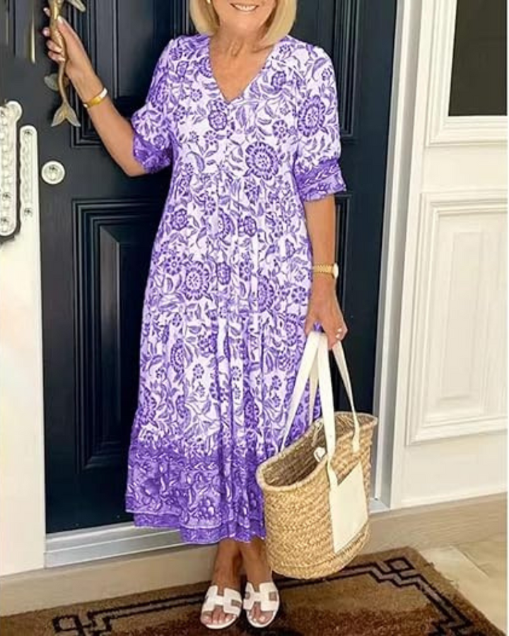 Elegant Summer Dress worn by model, front view, with purple and white floral print and straw bag