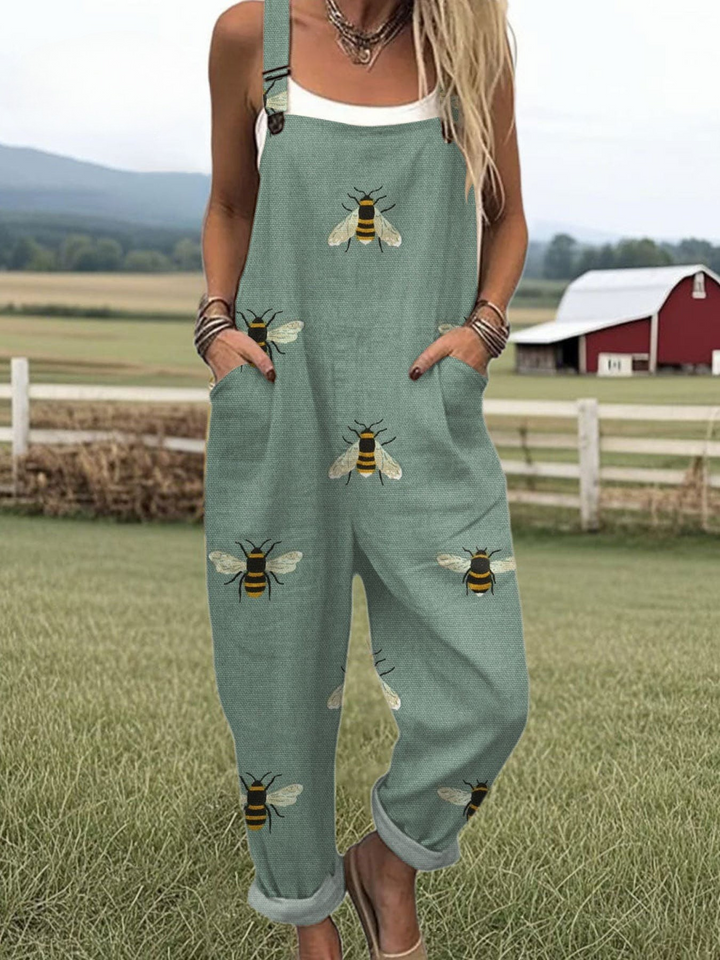 Front view of a model wearing a wide leg cotton jumpsuit with a bee art print and pockets
